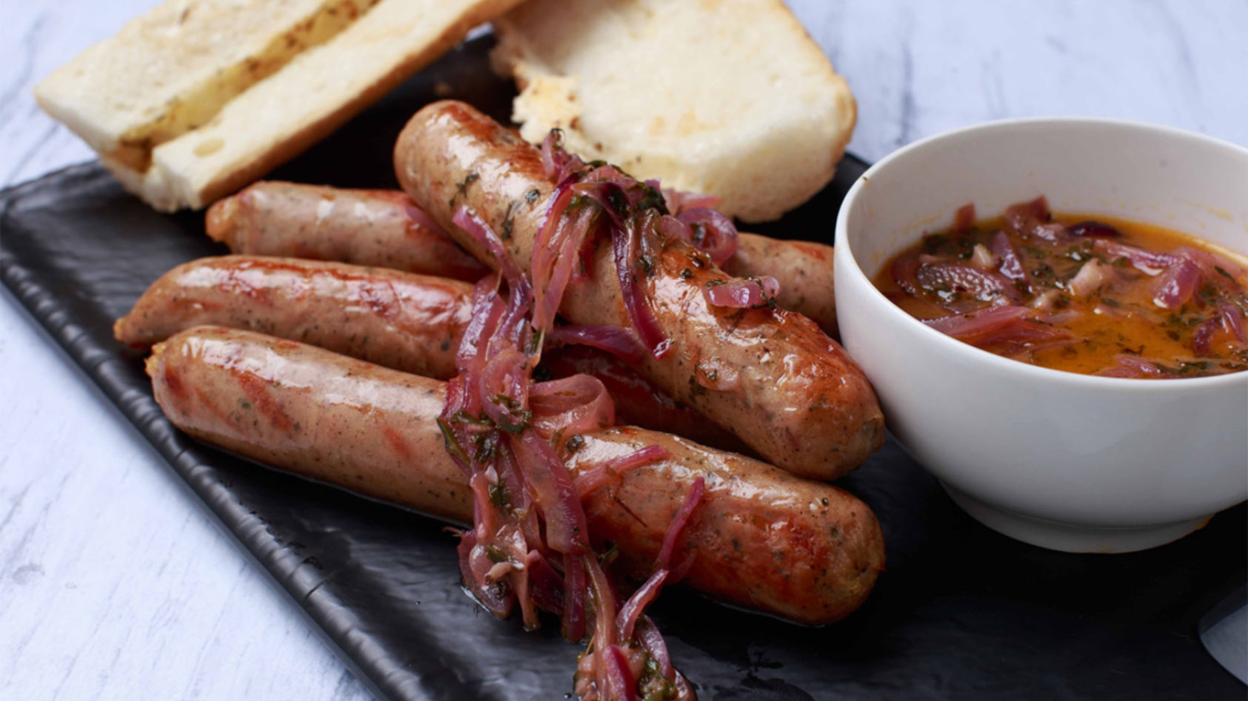 Salchichas Bratwurst asadas con salsa de ajo y perejil